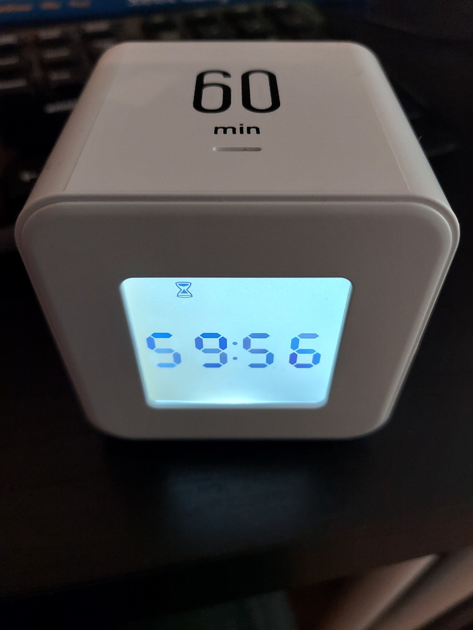 White cube clock/timer with 60 min on the cube top and 59:56 displayed on the clock face.
